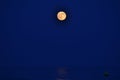 The moon rising over the horizon of the Mediterranean Sea. Photo taken from the shore of BenicÃÂ ssim beach Royalty Free Stock Photo